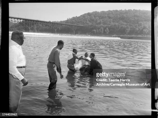 Calvary Baptist Church Deacon Clinton Robinson, Deacon Henry Robinson, and Rev. James M. Allen, baptizing man in Allegheny River, Pittsburgh,...