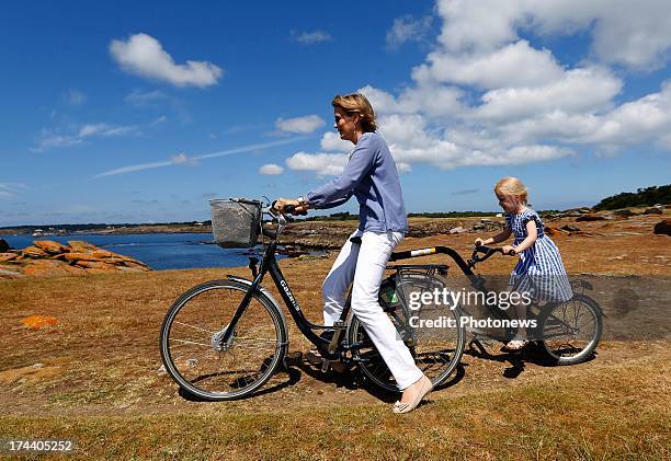 Queen Mathilde of Belgium rides on her bike with Princess Eleonore of Belgium during their holiday on l'Ile d'Yeu on July 24, 2013 in Yeu, France.