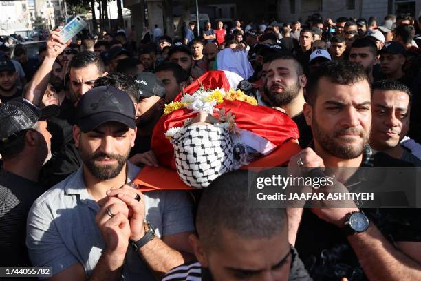 Mourners carry the body of Palestinian Ahmad Mutair, killed amid clashes with Israeli troops, from hospital to a cemetery in the occupied West Bank...