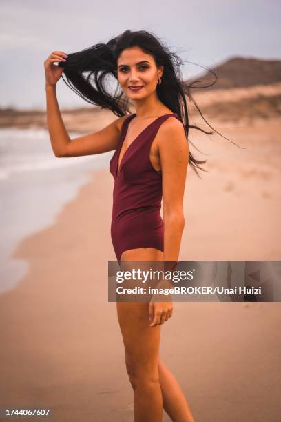 young caucasian brunette with a maroon swimsuit, summer on the beach of cabo de gata, nijar. andalucia, spain - zeitumstellung stock-fotos und bilder