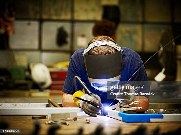 welder working in sheet metal shop - metallindustrie stock-fotos und bilder