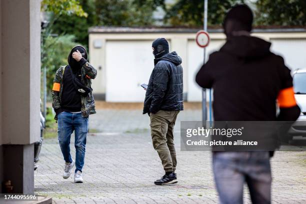 October 2023, North Rhine-Westphalia, Duisburg: Three police officers stand in the garage yard of the house where the man was arrested after his...