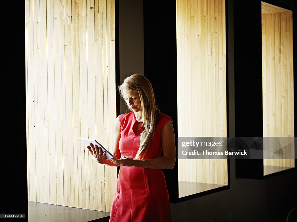 Businesswoman on digital tablet near office window