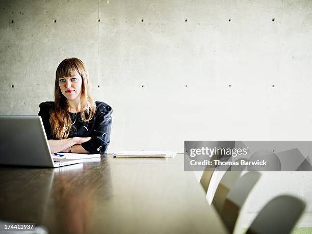 businesswoman on laptop in conference room - leanincollection stockfoto's en -beelden