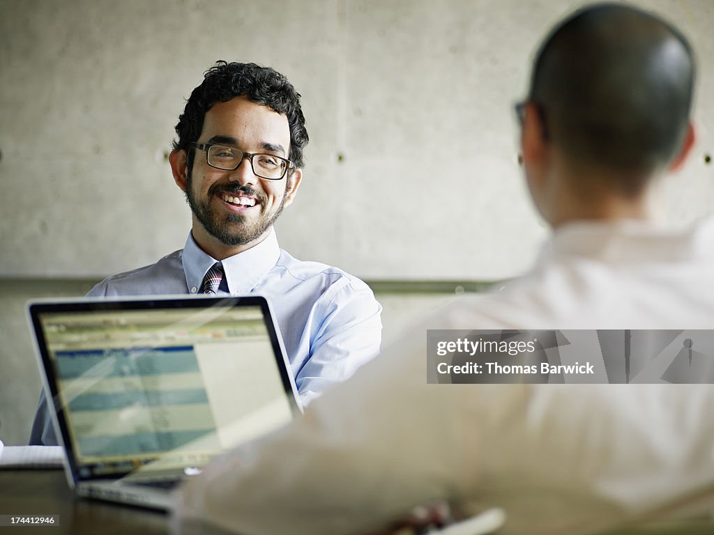 Two coworkers discussing project in office