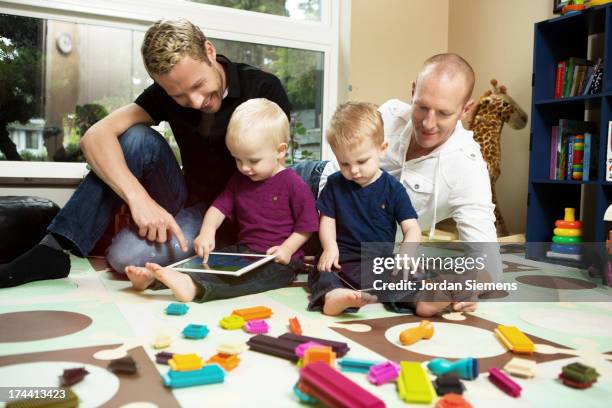 A Gay Male Couple Teaching Thier Two Kids, Stock-Foto