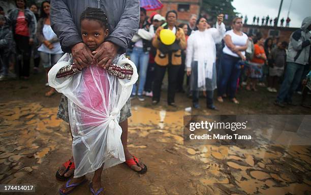 People watch as Pope Francis speaks in the Varghina favela, or shantytown, on July 25, 2013 in Rio de Janeiro, Brazil. More than 1.5 million pilgrims...