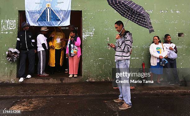 People await the arrival of Pope Francis in the Varghina favela, or shantytown, before Francis arrived for a tour on July 25, 2013 in Rio de Janeiro,...