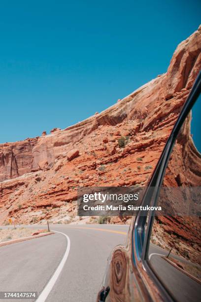 view from car window on red sand rocks in the canyon. orange maintains canyon scene. high red rocks. canyon desert red rocks in arches canyon, usa. - sightseeing in sedona stock pictures, royalty-free photos & images