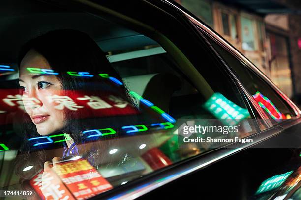 young woman in backseat of car, reflected lights - langues étrangères photos et images de collection