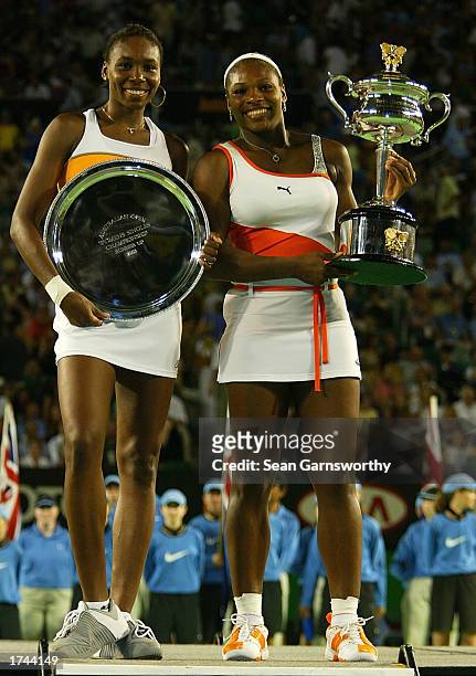 Serena Williams of the USA holds the winners trophy and her sister Venus Williams of the USA holds the runners up trophy after the Women's Singles...