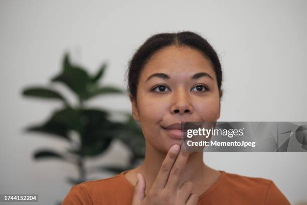 stress relief techniques. happy calm african american woman using eft tapping to relieve stress and anxiety, touching face with fingertips. emotional freedom technique - pressure point 個照片及圖片檔