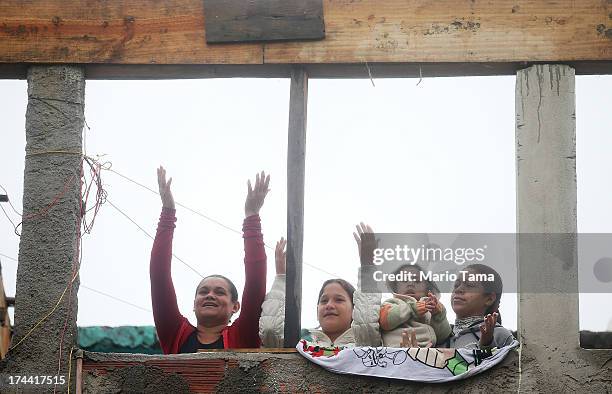 People sing to music being played before Pope Francis arrived in the Varghina favela, or shantytown, on July 25, 2013 in Rio de Janeiro, Brazil. More...