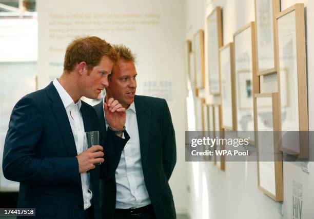 Prince Harry and photographer Chris Jackson view Jackson's photographs based on the work of the Sentebale charity at the private view of the...