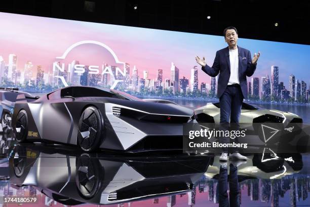 Makoto Uchida, chief executive officer of Nissan Motor Co., speaks on stage next to the Hyper Force concept, left, at the Japan Mobility Show in...