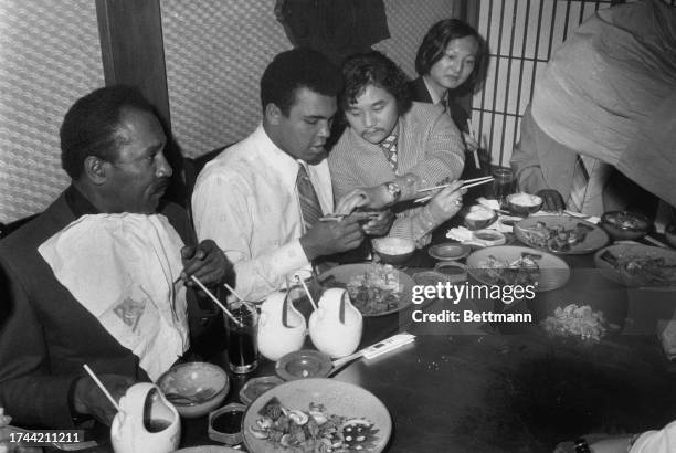 Former wrestler Rocky Aoki , owner of the Benihana of Tokyo restaurant, teaches Muhammad Ali to eat with chopsticks during lunch in New York,...