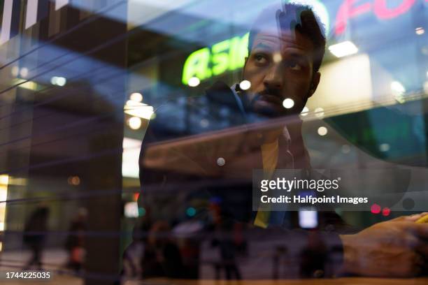 young man sitting alone in a food court restaurant. single man dining out simple fast food in shopping mall. - man eating at diner counter foto e immagini stock