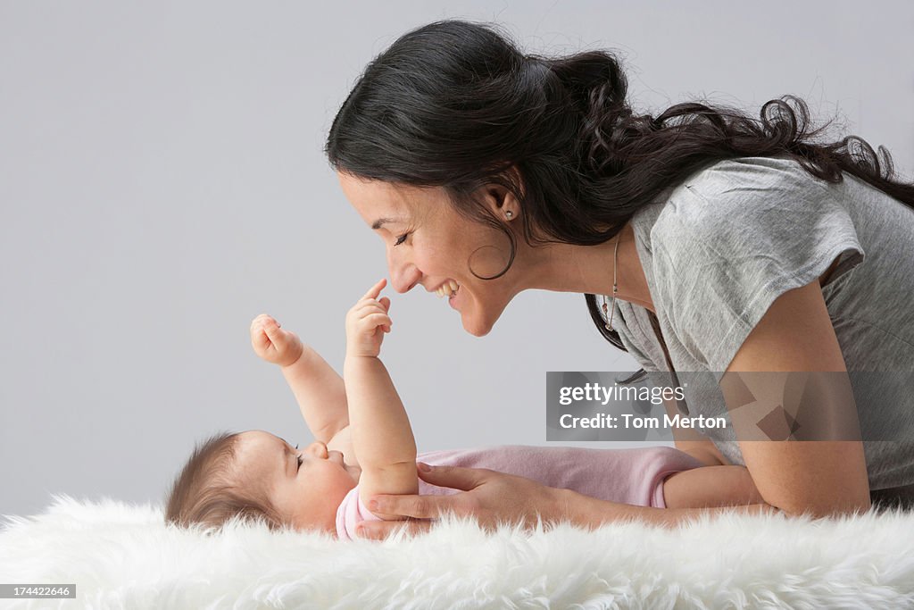 A woman playing with a baby