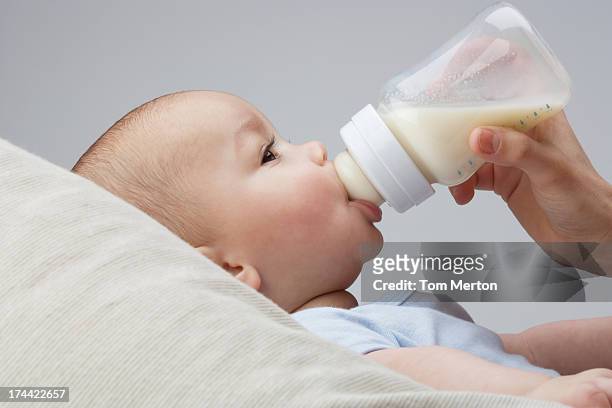 um bebê ser alimentados com garrafa de leite - mamadeira - fotografias e filmes do acervo