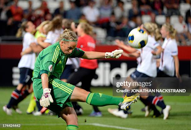 Denmark's goalkeeper Stina Petersen kicks the ball as Norway's players celebrate after winning the penalty shootout of the UEFA Women's European...