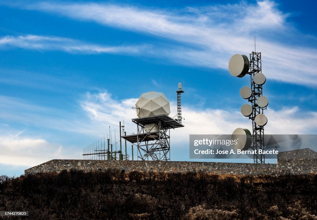 Radar station and telecommunications tower on top of a mountain.