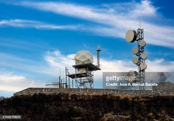 radar station and telecommunications tower on top of a mountain. - weather station stock pictures, royalty-free photos & images