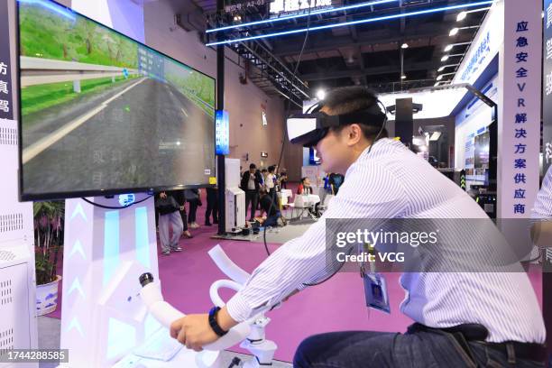 Visitor wearing VR headset tries indoor cycling during an expo of 2023 World Conference on VR Industry on October 19, 2023 in Nanchang, Jiangxi...