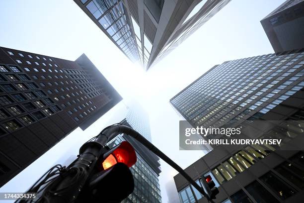 Red traffic light is pictured under high-rise buildings in the banking district during a foggy morning in Frankfurt am Main, western Germany, on...