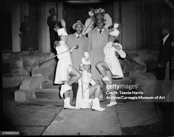 Three majorettes and two young men posed on steps, Pittsburgh, Pennsylvania, c. 1950