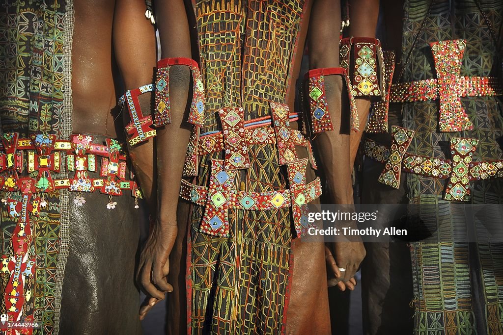 Men holding hands wearing tribal designs
