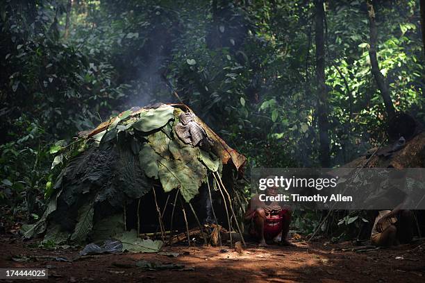 tribal woman sitting by primitive jungle hut - native african ethnicity stock pictures, royalty-free photos & images