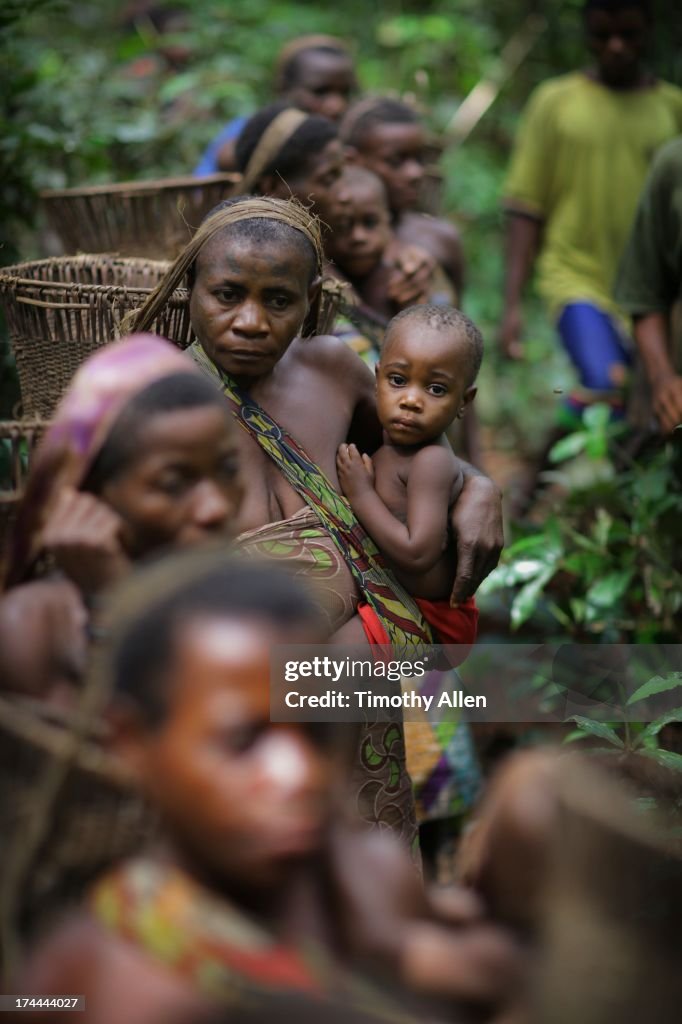 A line of women holding children in baby slings