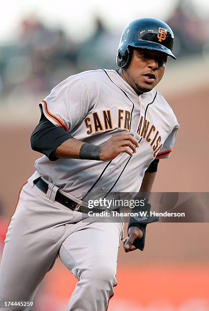 Tony Abreu of the San Francisco Giants rounds third base to score on a Pablo Sandoval two-run double in the first inning against the Cincinnati Reds...