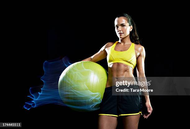 sports woman with yoga ball on fire - bauchfreies oberteil stock-fotos und bilder