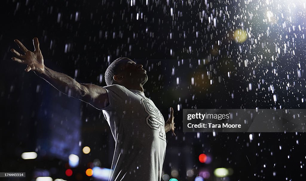 Man with arms in air in the rain
