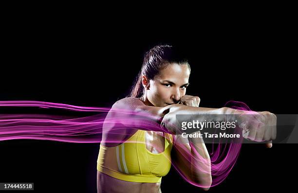 sports woman punching air with light trails - combat sport stock pictures, royalty-free photos & images