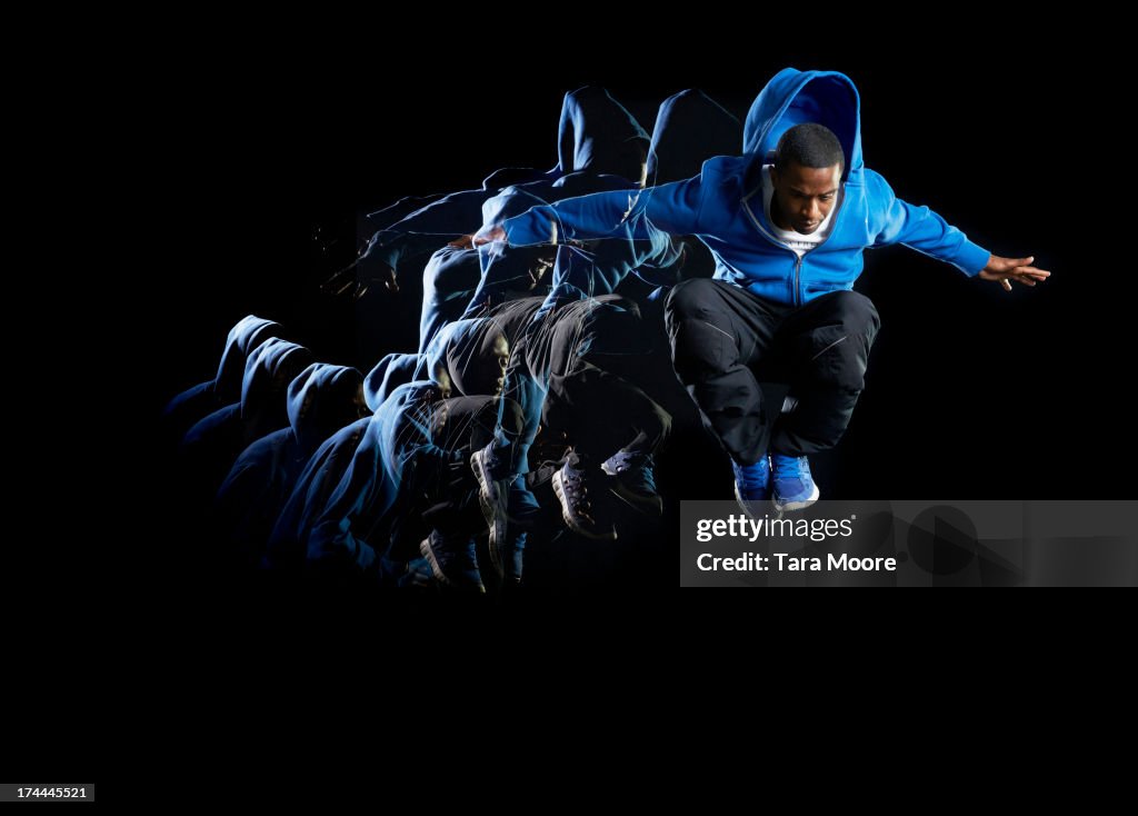 Urban man jumping in air with multiple strobe