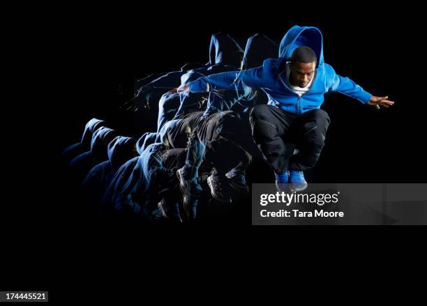 urban man jumping in air with multiple strobe - sport performance stock pictures, royalty-free photos & images