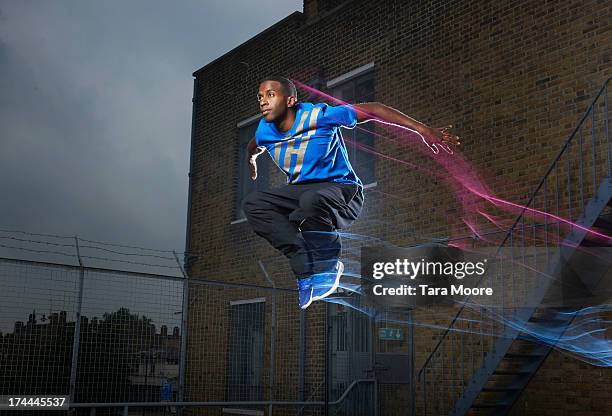 man jumping on rooftop with light trails - people in mid air stock pictures, royalty-free photos & images