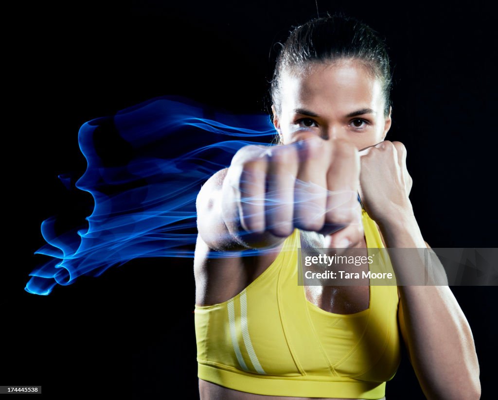 Woman punching air with fist on fire