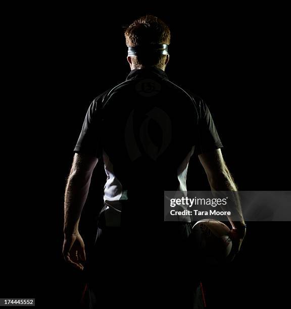 back view of rugby player holding rugby ball - rugby imagens e fotografias de stock