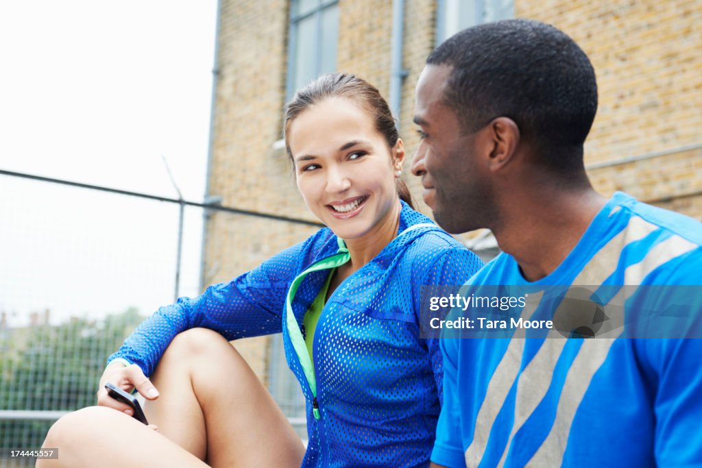 Fitness man and woman talking with mobile phone