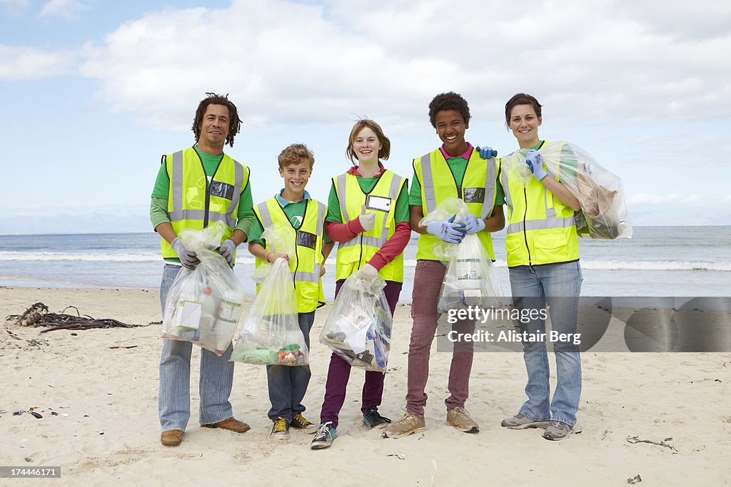 Young people cleaning up rubbish on a beach