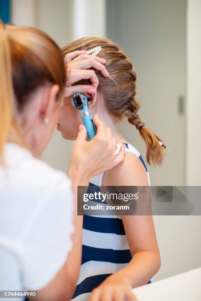 otolaryngologist examining girl patient's ear with otoscope in the office - ear exam stock pictures, royalty-free photos & images