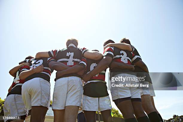 rugby players together in a huddle - rugby sport stock-fotos und bilder