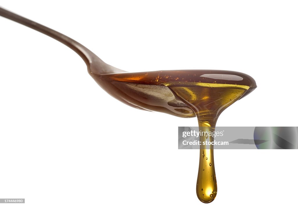 Spoon with dripping sirup or honey close-up