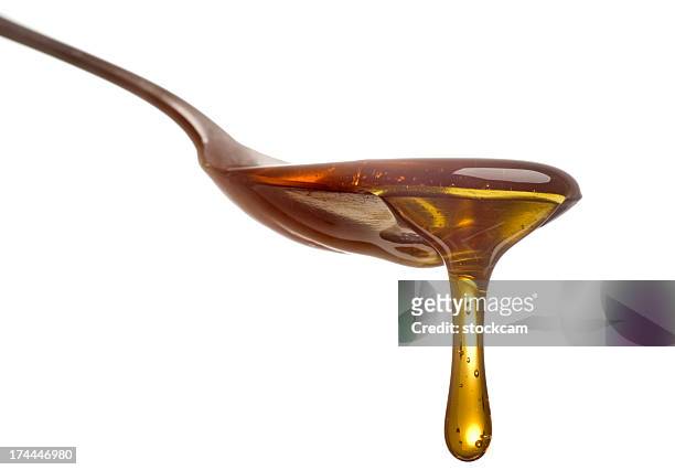 spoon with dripping sirup or honey close-up - syrup stock pictures, royalty-free photos & images