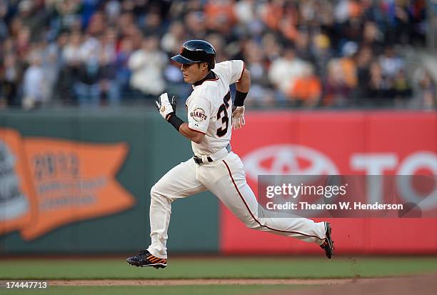 Kensuke Tanaka of the San Francisco Giants goes from first to third on a double by Andres Torres in the ninth inning against the Cincinnati Reds at...