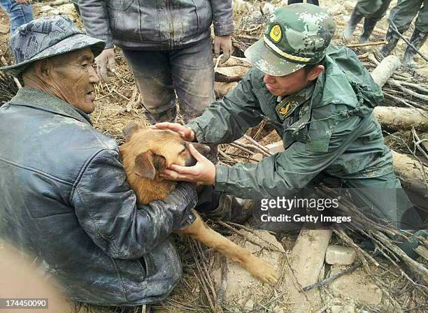 Dog is rescued by soldiers from a collapsed house 77 hours after the earthquake on July 25, 2013 in Minxian, China. At least 95 people were killed...