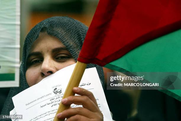 Palestinian woman holds up her national flag during a demonstration to mark "Land Day" 30 March 2004 in Khan Yunes in the southern Gaza Strip. Land...